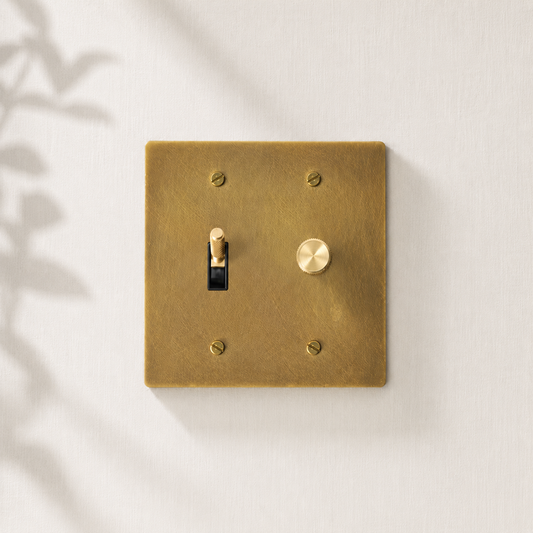 Solid brass toggle and dimmer switch with a brushed finish.