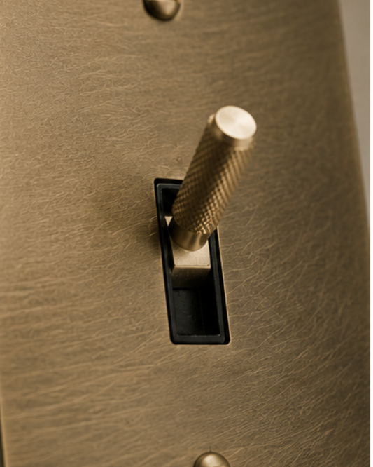 Close-up of three solid brass toggle switches showing precision craftsmanship.