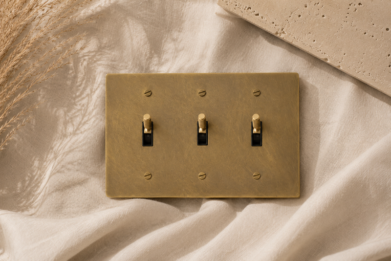 Triple solid brass toggle light switch with a brushed finish.